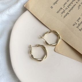 Серьги переплетены кольца золотистого цвета